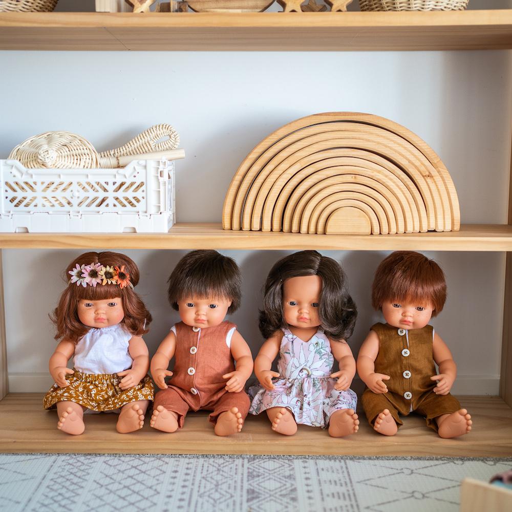 Miniland Doll collection of brunette and red haired baby dolls on wooden playshelf