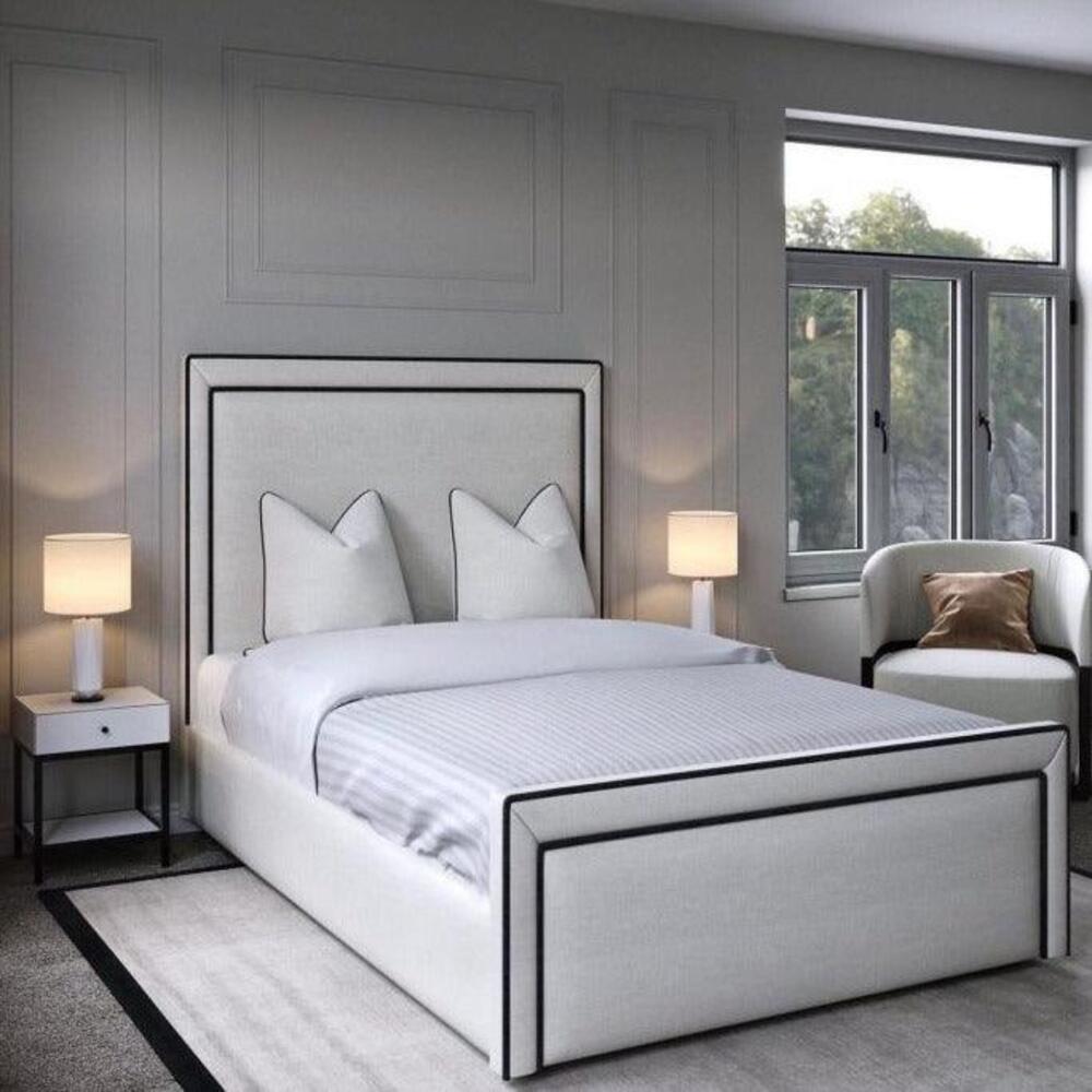 Modern bedroom with kingsize divan bed, white bedding, bedside tables, and lamps.