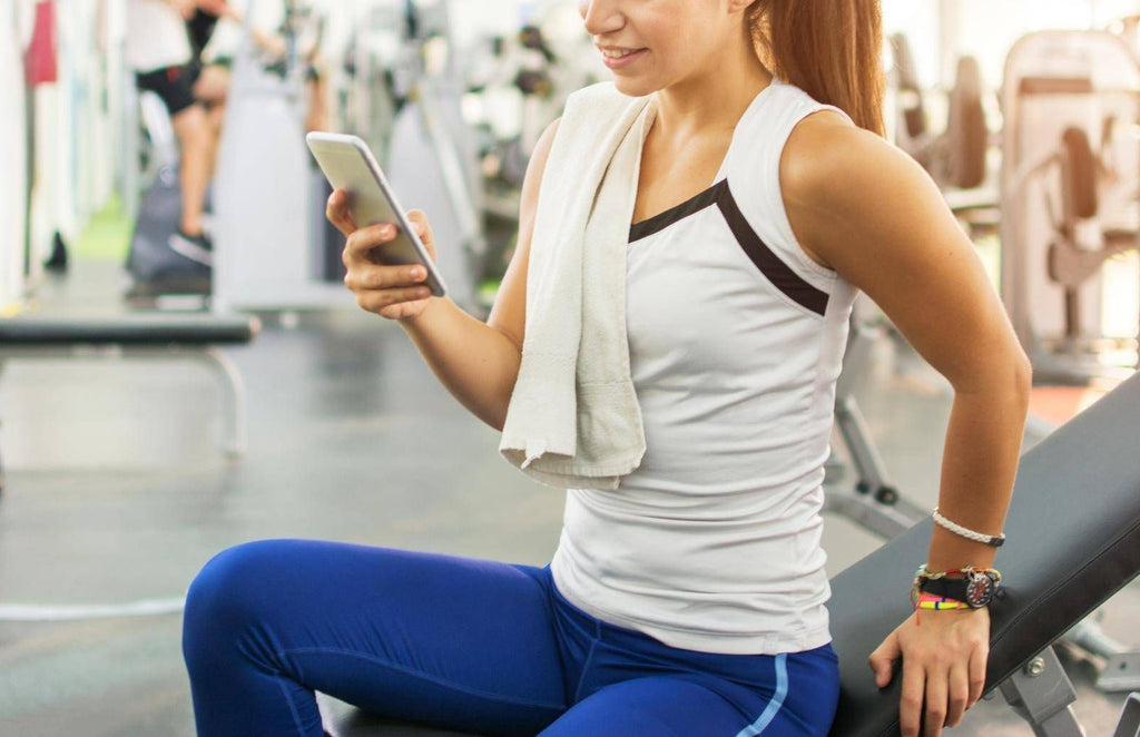 woman texting in the gym