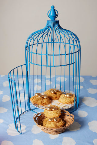 open blue bird cage with edible nests for surrealist party dessert