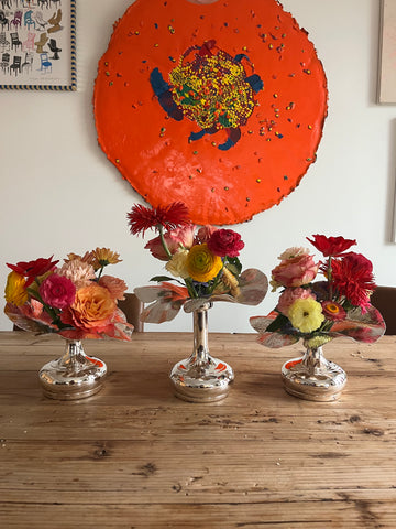 colorful rainbow flowers in flower shaped silver bud vases