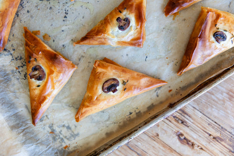 Golden brown mushroom turnovers in phyllo dough on parchment paper