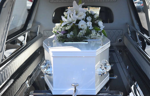 white funeral casket with flowers