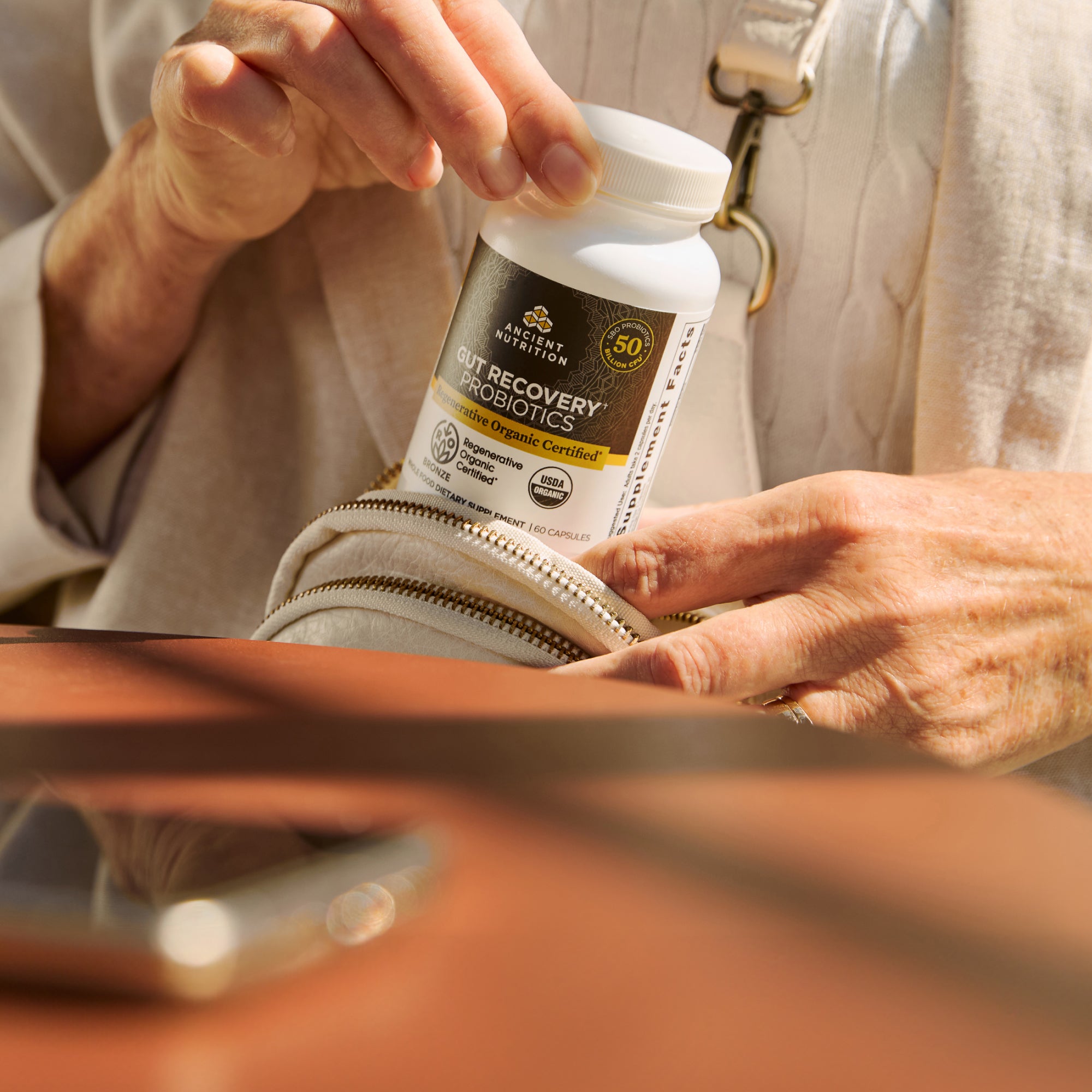 a person taking a bottle of Regenerative Organic Certified® Gut Recovery Probiotics Capsules (60 Capsules) out of their bag