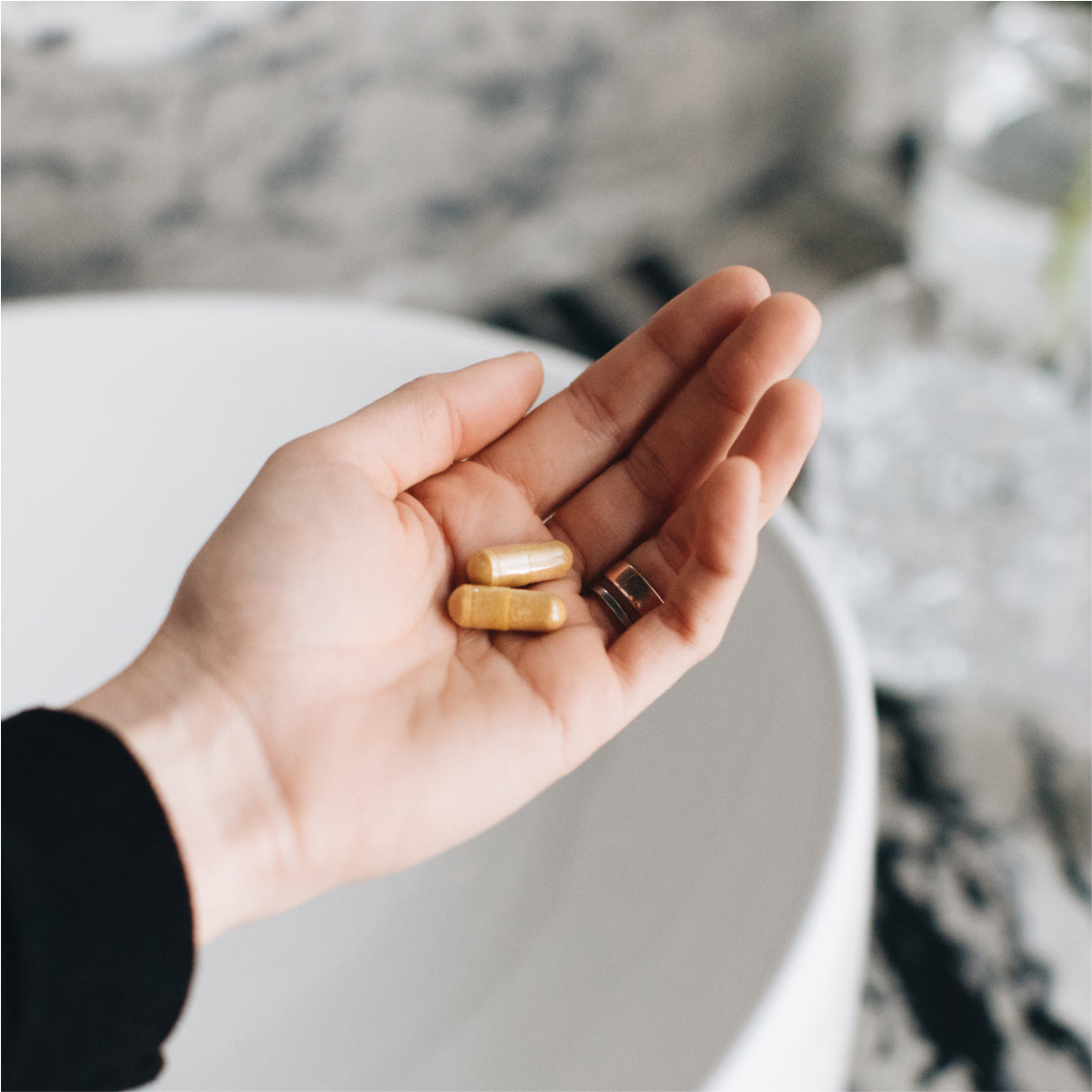 person putting multi collagen capsules joint + mobility in their hand