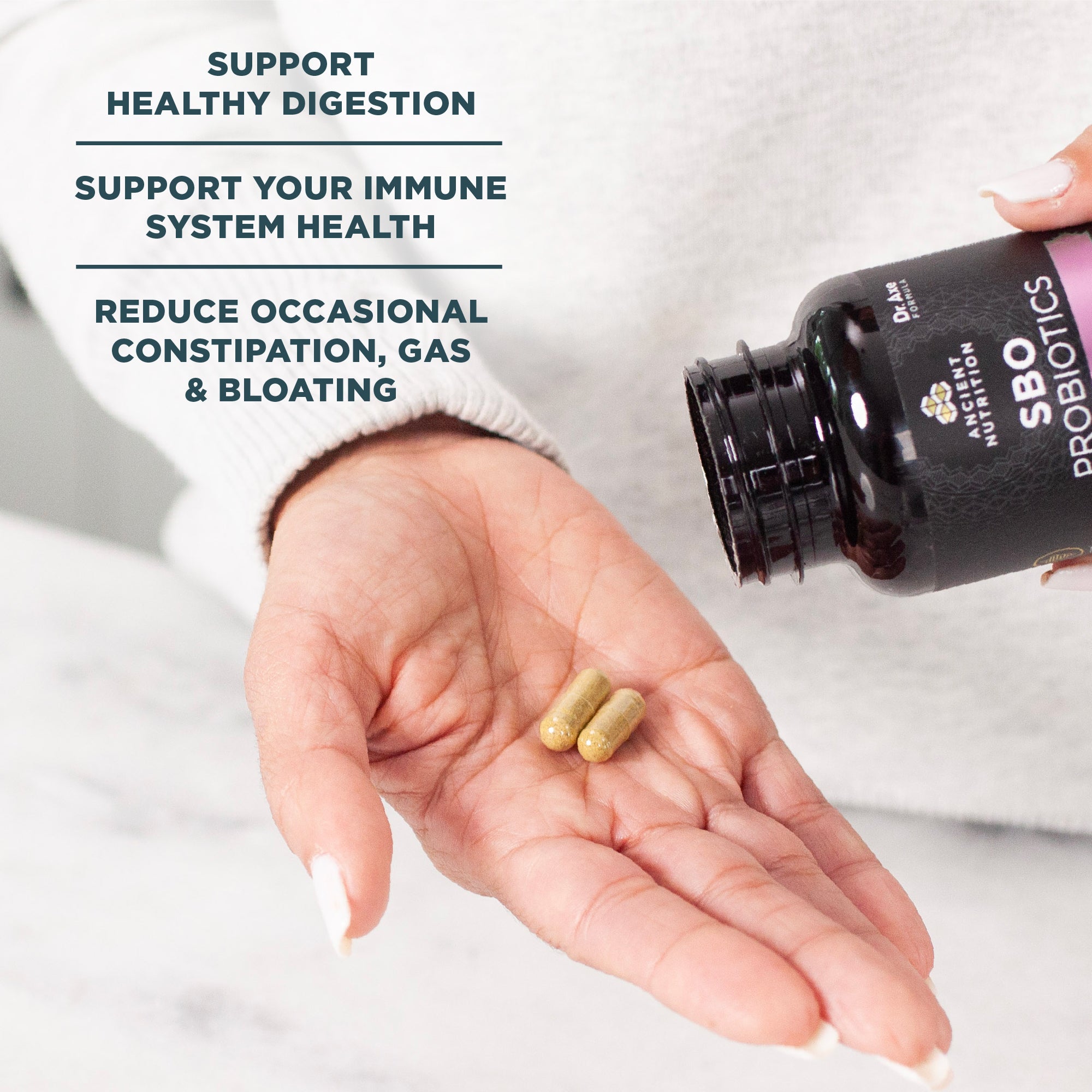 person putting SBO Probiotics Women's Capsules in hand