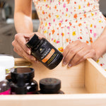 woman taking vitamin C + probiotics out of a drawer