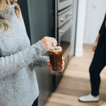 girl stirring cold brew in a glass cup