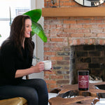 girl drinking coffee by fireplace