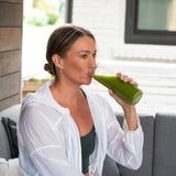 a woman drinking a green juice