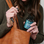 a woman taking Organic Super Greens + Organic Multi Tablet out of her purse