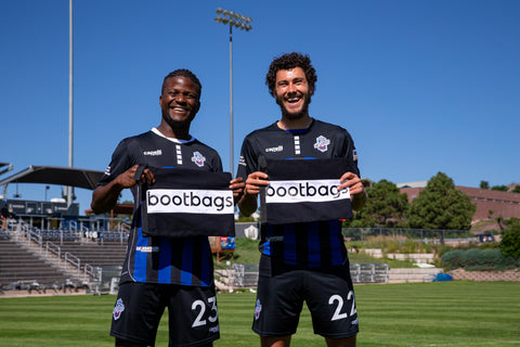 Shane Malcolm (left) and Jordan Schweitzer (right) holding bootbags