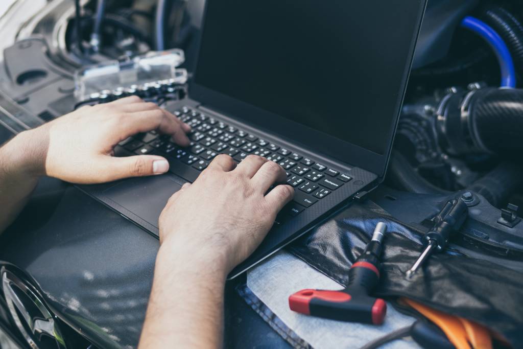 Male driver ECU tunes his car with a Windows laptop