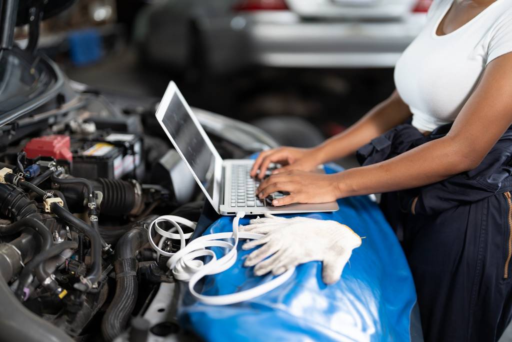 Woman implements ECU tuning mods on car with laptop