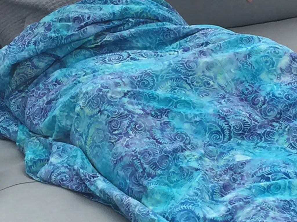 Handmade custom weighted blanket in blue swirled fabric by Mosaic, crafted in Austin, Texas for personalized comfort and quality