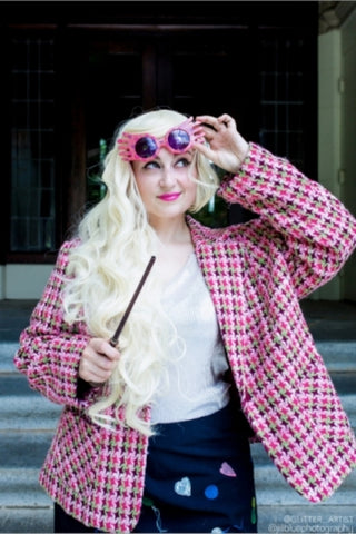 Portrait of Christiana Sayyah, hairstylist. She has long blonde hair and is dressed as the characted Luna Lovegood from the Harry Potter franchise.