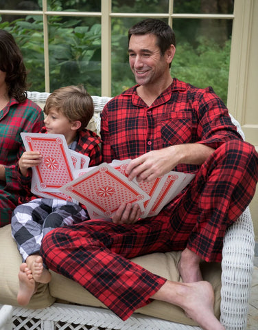 Dad reading a bedtime story to his child in Lazy One matching pajamas.