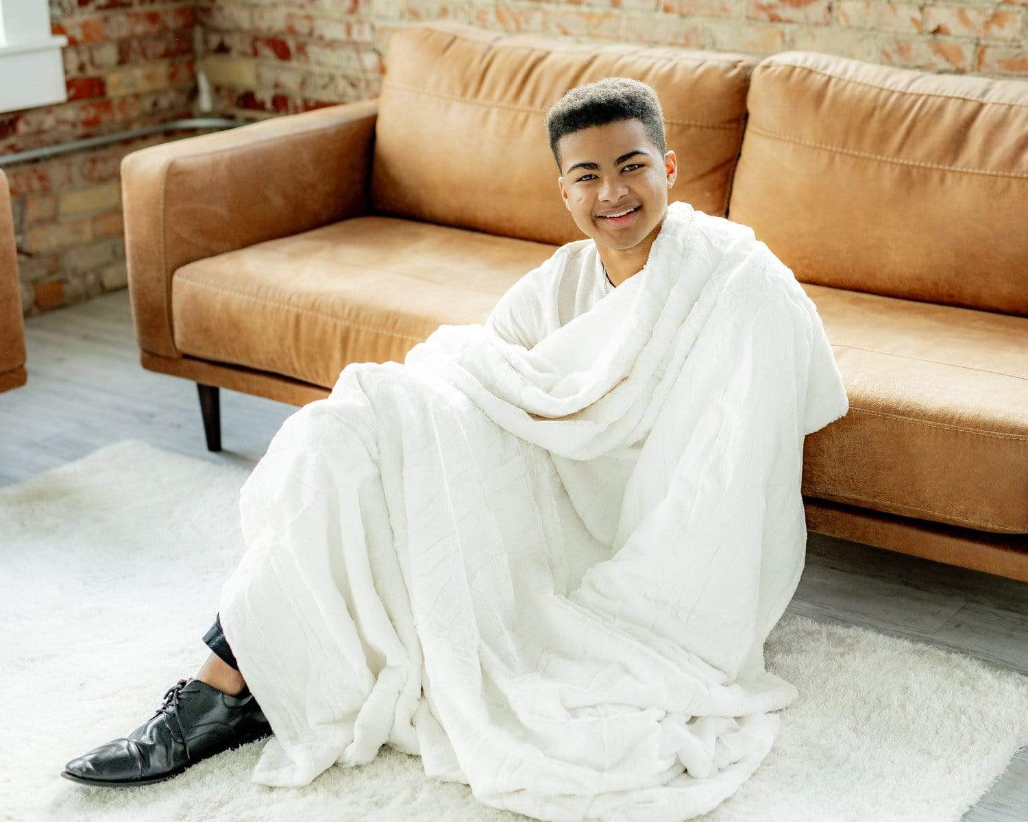 Young man sitting with the sorbet vanilla blanket by Minky Couture.  Zoom - 3