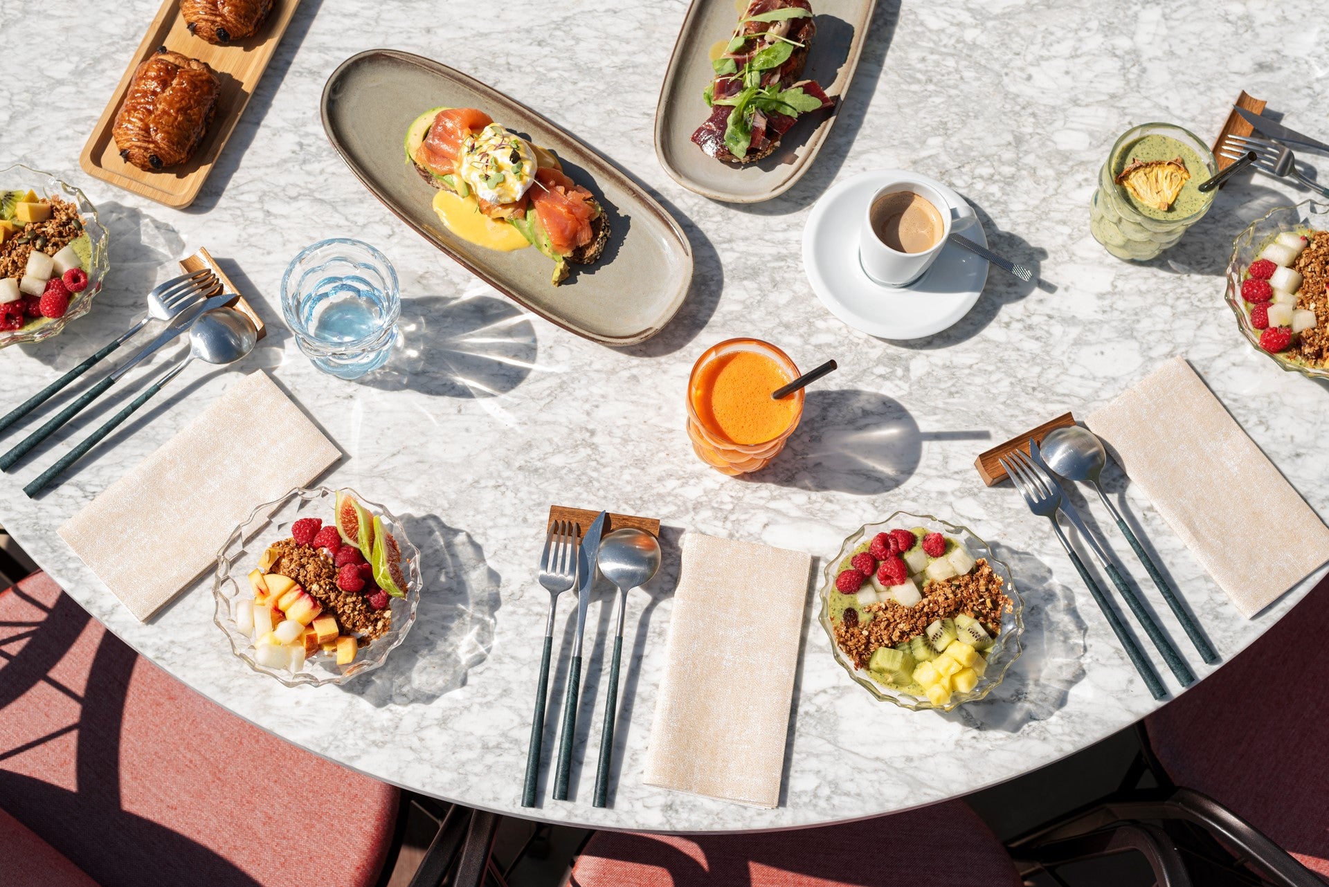 Breakfast options taken from above. Croissants, egg Benedict, smoothie bowl, orange juice and coffee