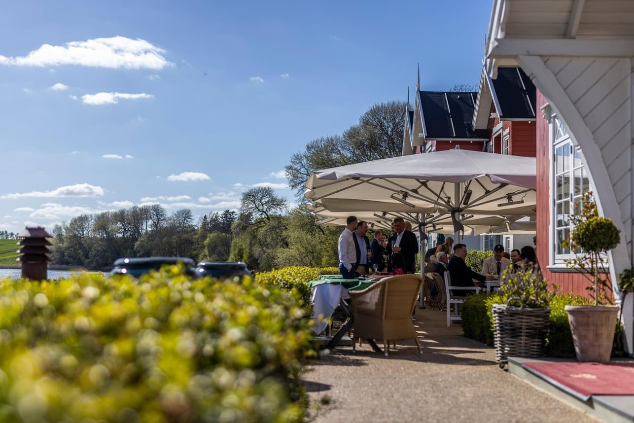 Dyvig Badehotel restaurant stemning, grønne buske, udendørs spisemøbler, Cane-line Lansing spisebordsstole 