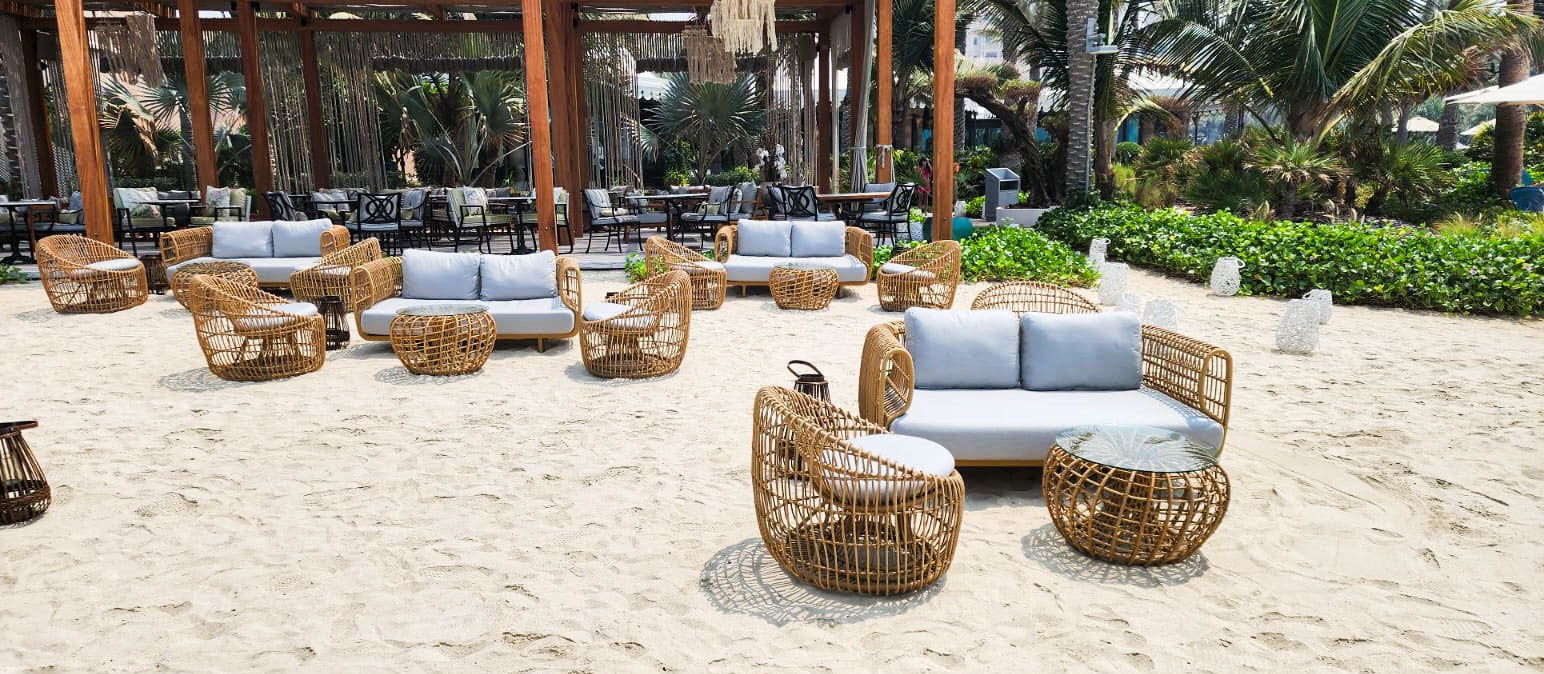 Restaurant lounge by the beach with design lounge sofa, lounge chair and round coffee table from Cane-line Nest series