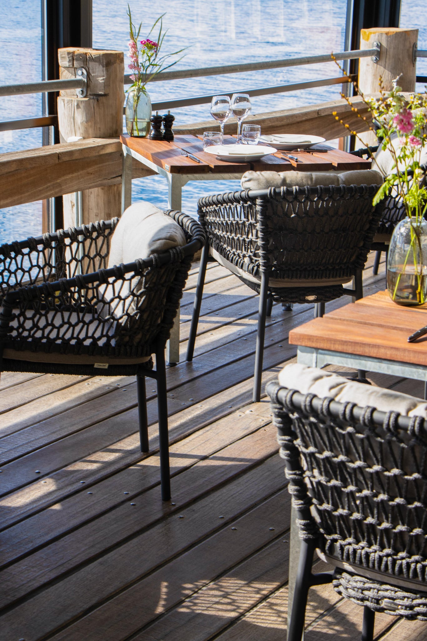 Close up of Cane-line Ocean dining chairs in lava grey at Hey IDA, fine dining setting, square tree dining table, ocean view at Kalvebod Brygge in Copenhagen