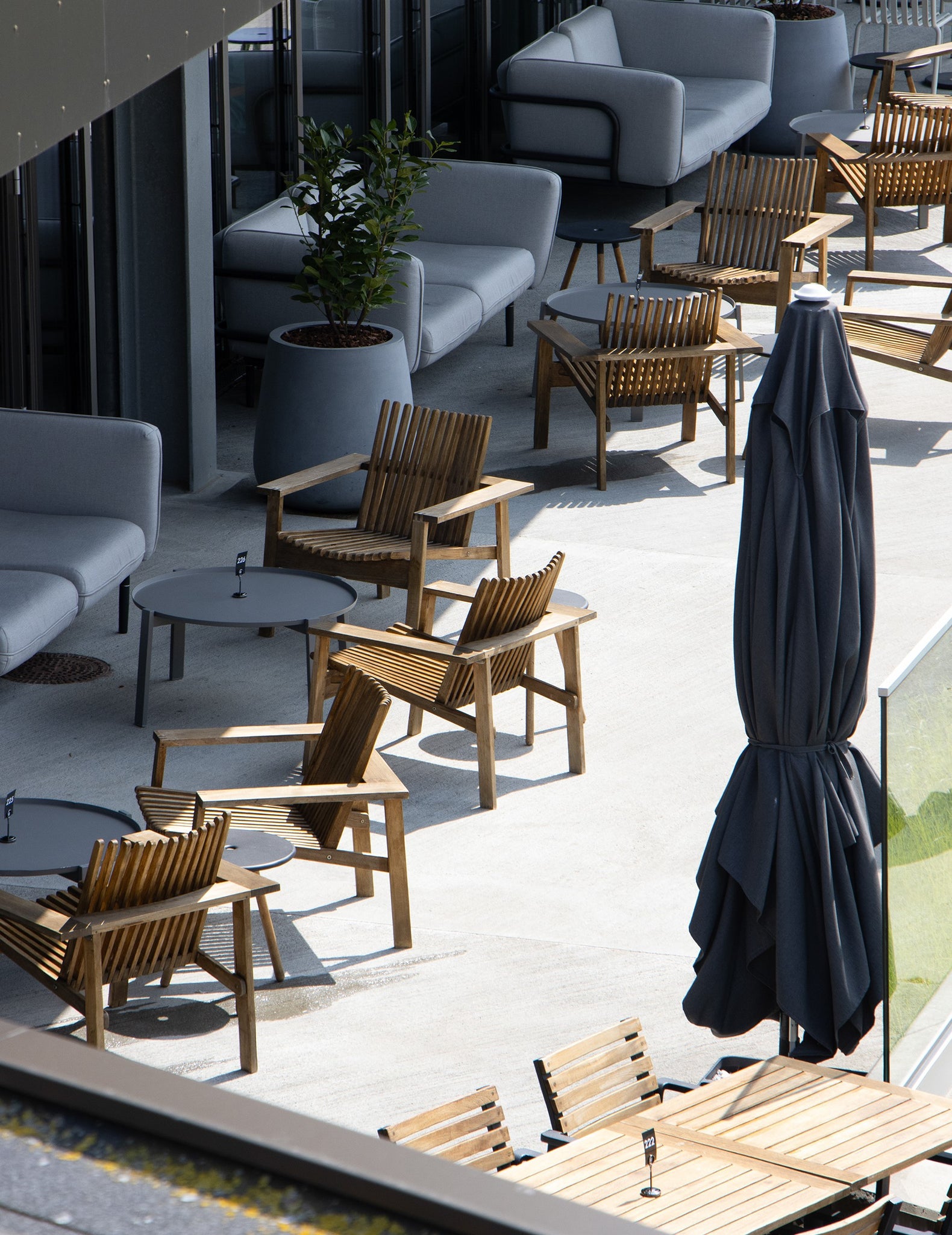 Alsik Restaurant outdoor terrace with Cane-line black Parasols and Amaze lounge chairs made of teak 