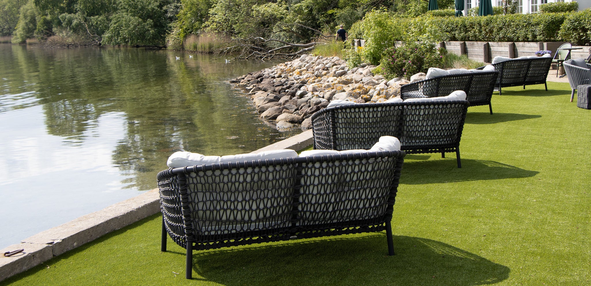 Outdoor lounge area at Dyvig Badehotel with view over water, Back of the black Ocean lounge sofa 