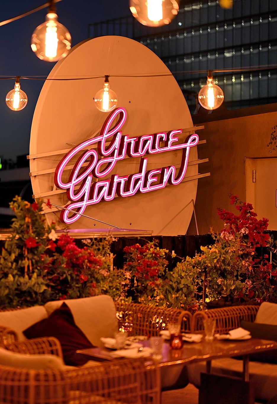 Lighting chains, close up of Grace Garden pink neon sign, Cane-line Nest lounge chairs nature