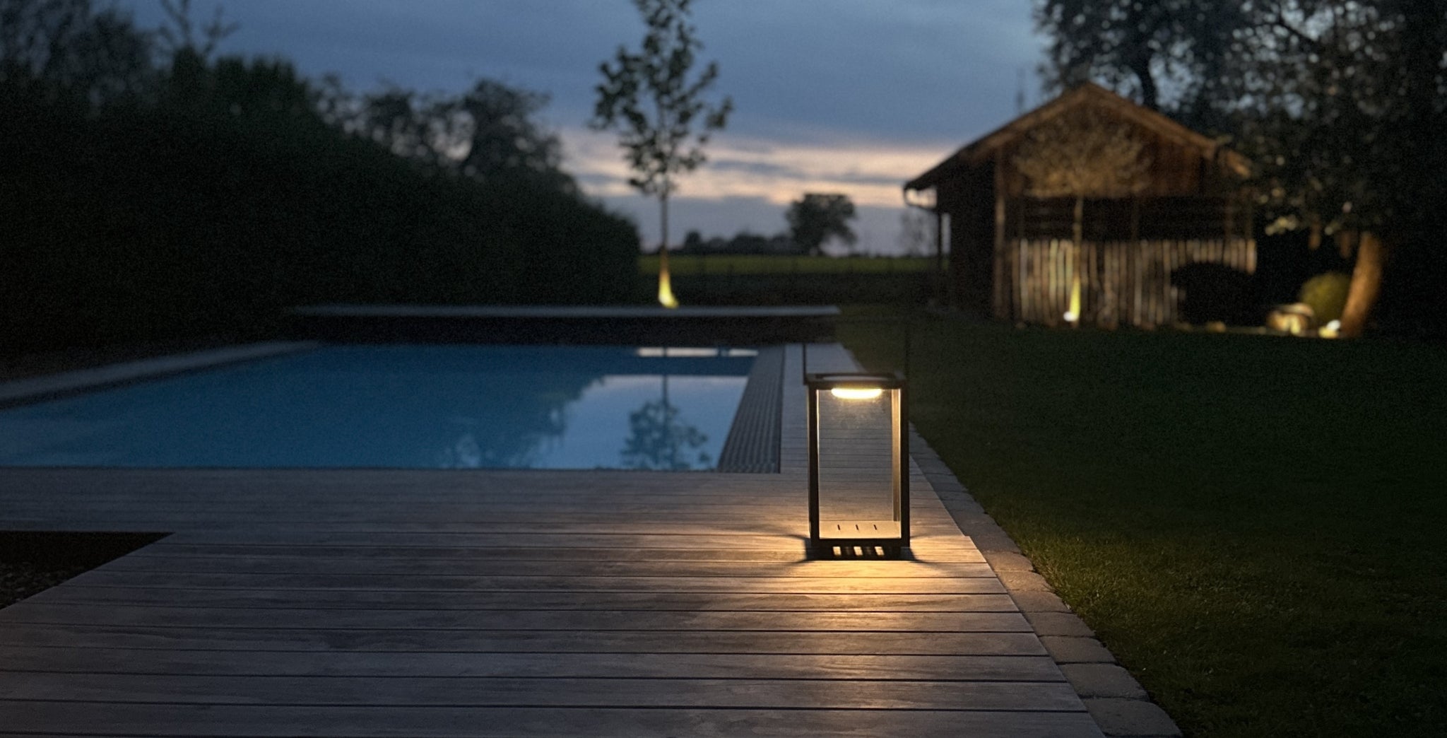 Black lantern with LED light by the pool for outdoor lighting