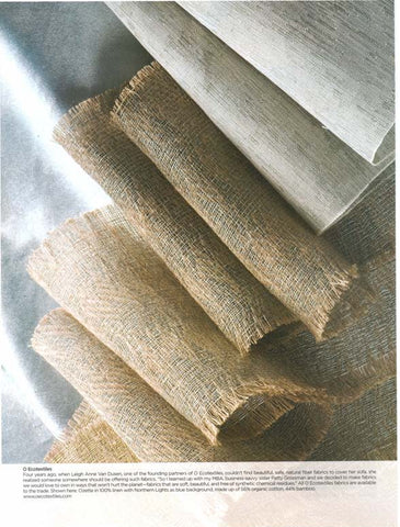 Rolls of beige, natural textile on top of a different, softer looking blue fabric