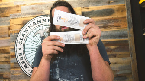 Ross holding two packets of Abbey Ale yeast from White Labs