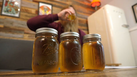jars of harvested yeast in foreground and emmet drinking beer in background