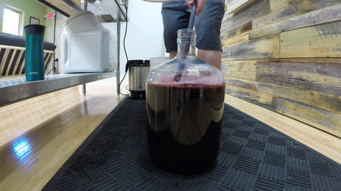 adding porter to carboy with berries