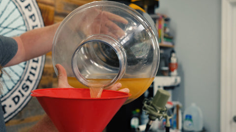 pouring the milky top layer into a smaller 3 gallon carboy