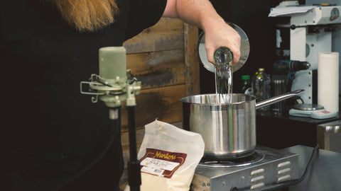 putting 2 liters of water into a pot on a hot plate