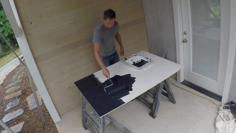 putting first coat of chalkboard paint onto plywood