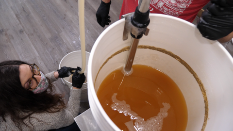 siphoning our beer into a bottling bucket