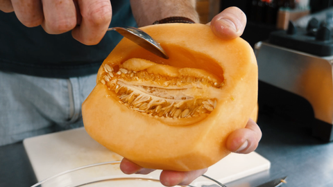 removing cantaloupe seeds using a spoon