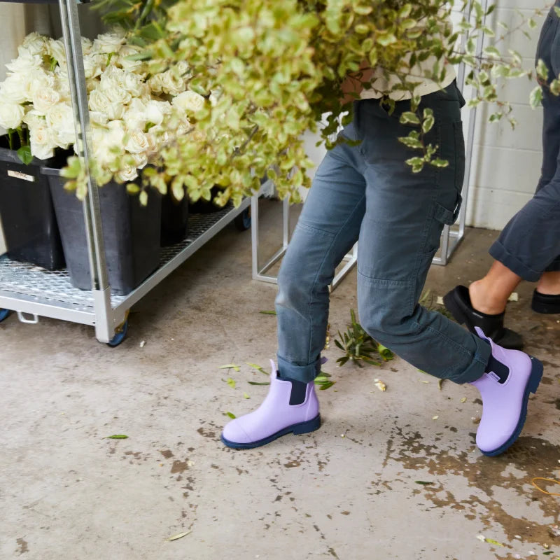 person wearing lavender boots holding flowers