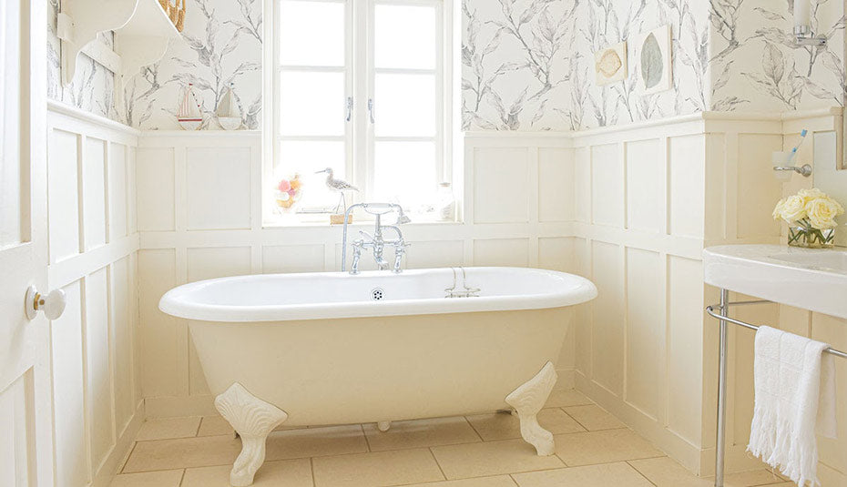 A cleanly decorated bathroom with sketch-like wallpaper.