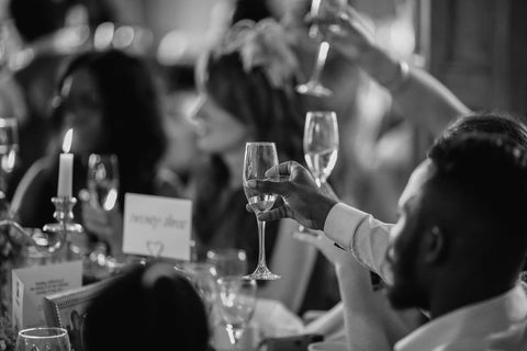 black and white photo of people toasting with glasses