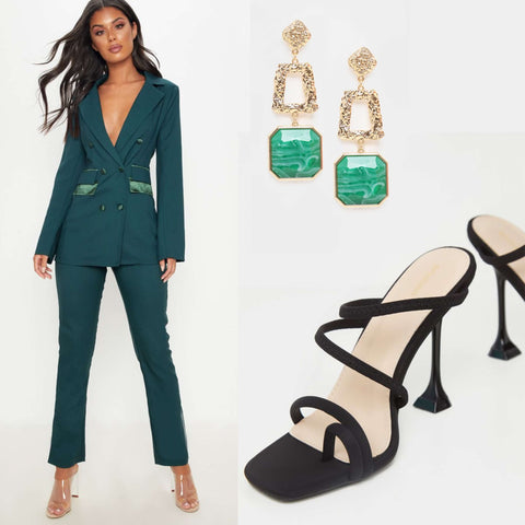 model in emerald green suit, black shoes and gold and green statement earrings 