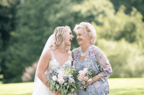 mother and bride smiling, wedding dress, blue dress