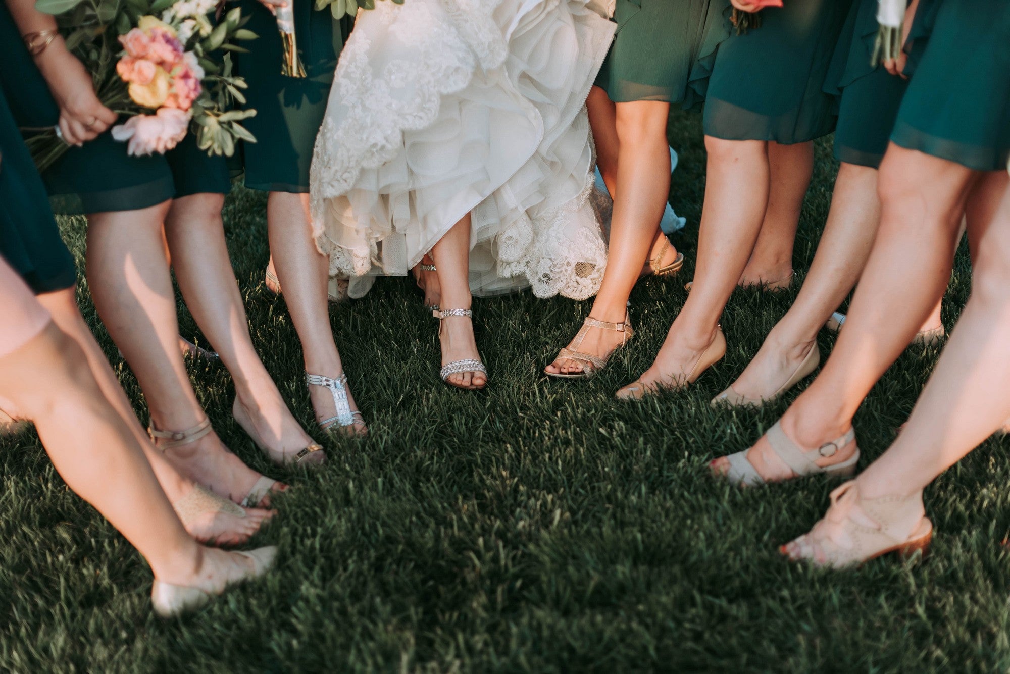 a group of women showing their wedding footwear from knee down