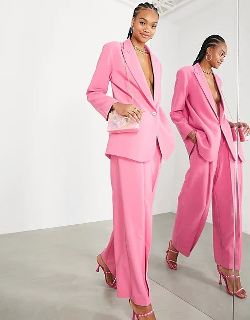 a model standing beside a mirror showcasing the stunning pink wide leg ASOS trousers.