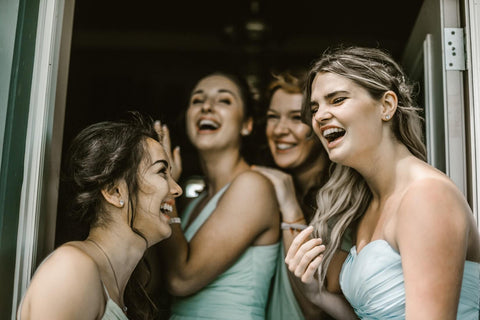 bridesmaids laughing in a doorway