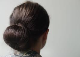 a woman with brown hair in a bun 