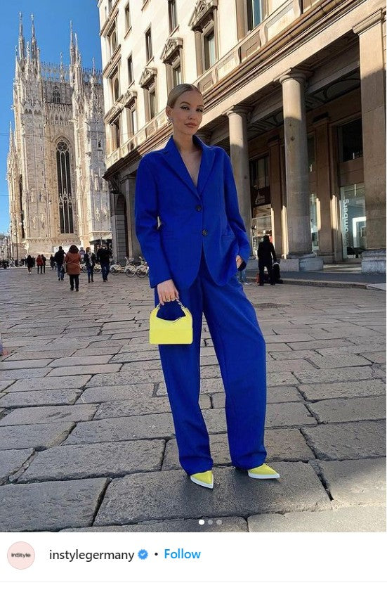 a screengrab of a blue suit and yellow handbag being worn by a model to show inStyle Germany's support for Ukraine.