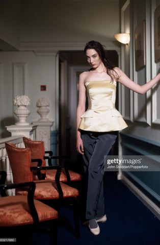 Jasper Conran peplum gold satin strapless top with peplum and pocket flaps on a dark haired model.